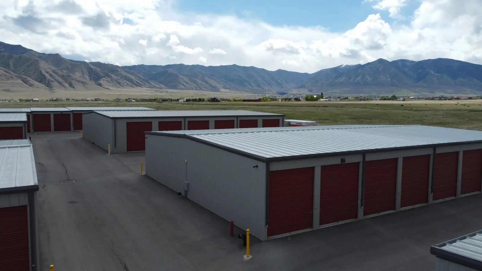 Drive lane between pre-engineered metal self-storage buildings with mountains beyond, Erda UT