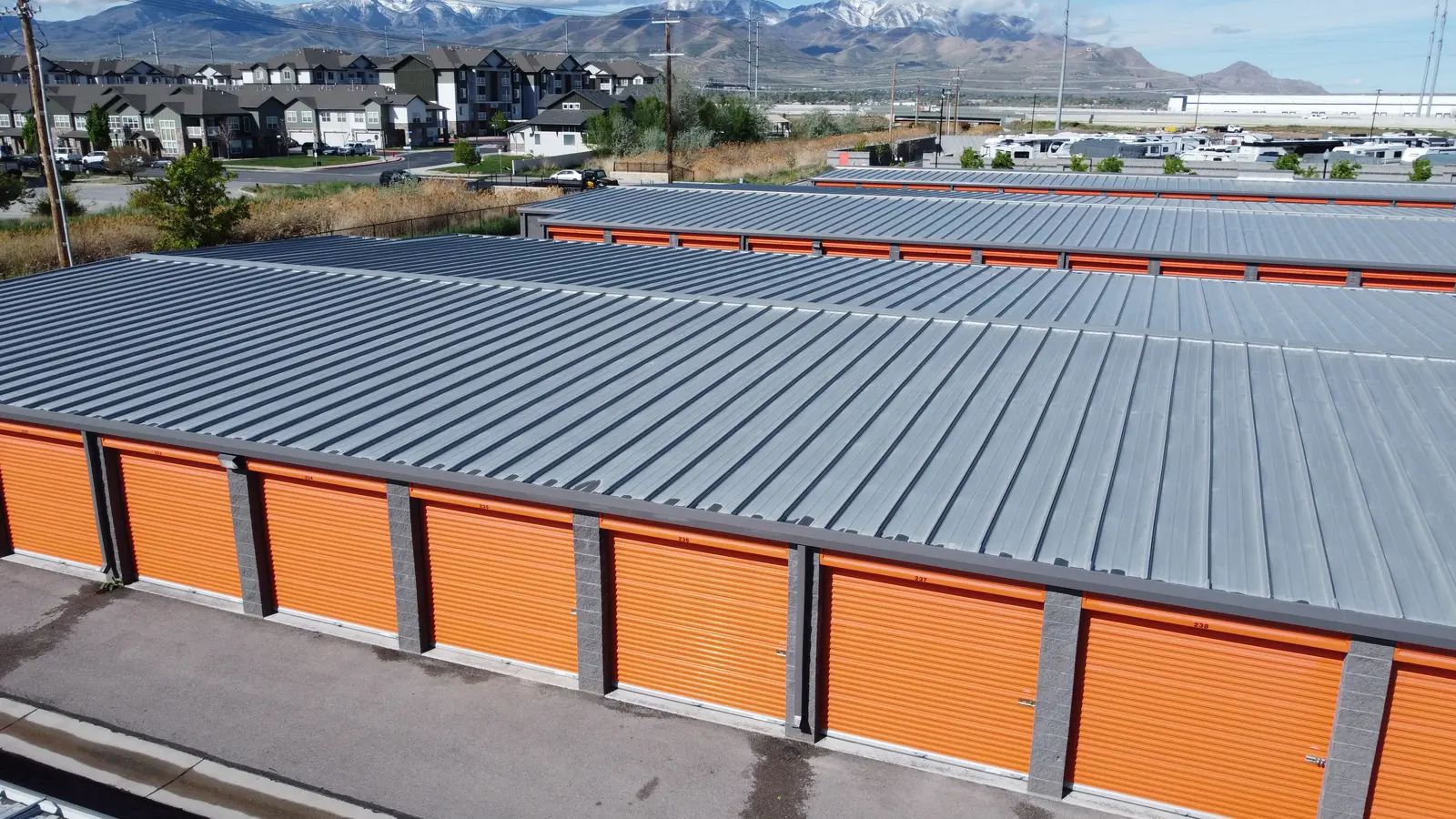 Orange roll-up doors on a pre-engineered steel self-storage building, West Valley City Utah
