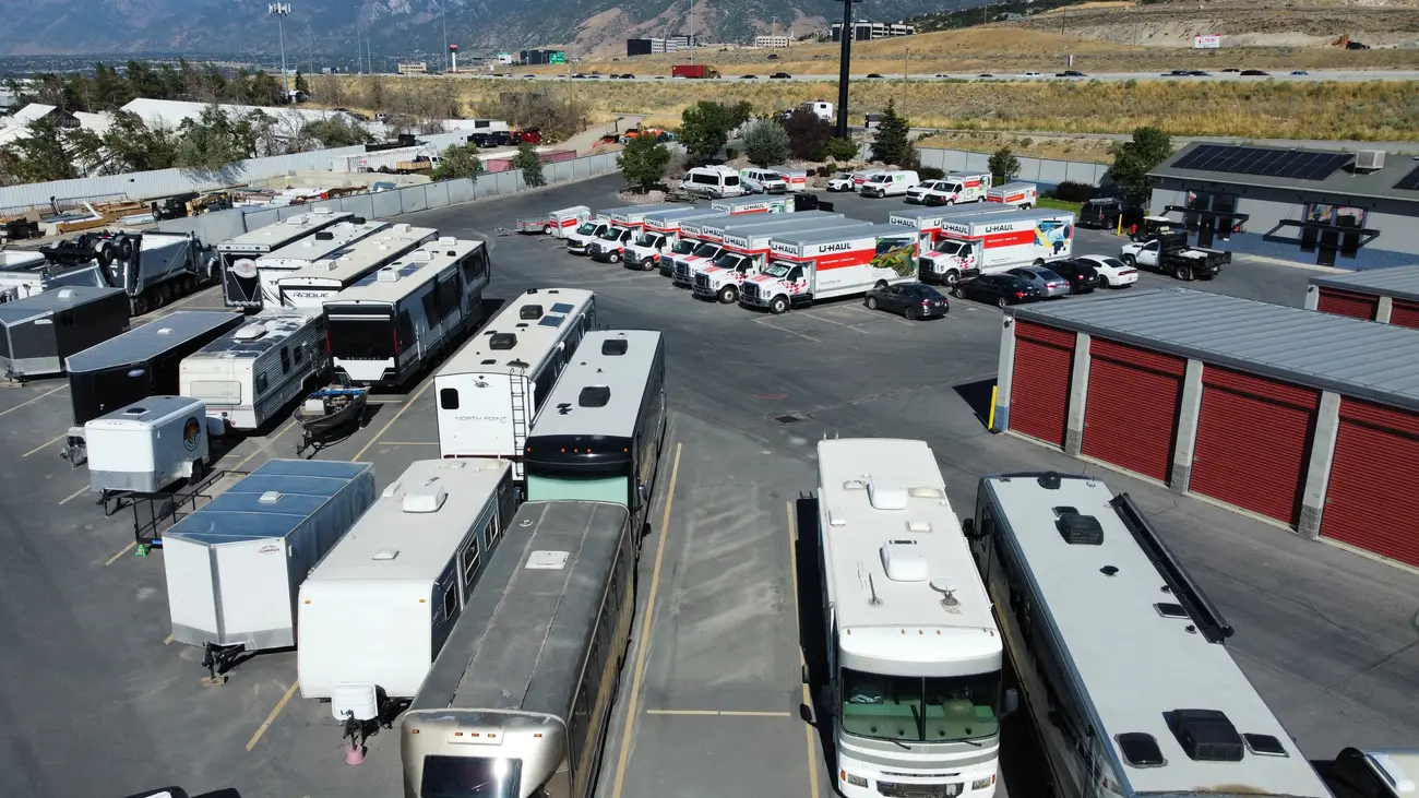 Rows of motorhomes, trailers, and boats in covered and open RV storage